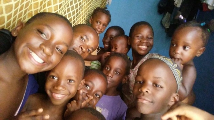 Nine of the Desire Kids crowded together, laughing into the camera